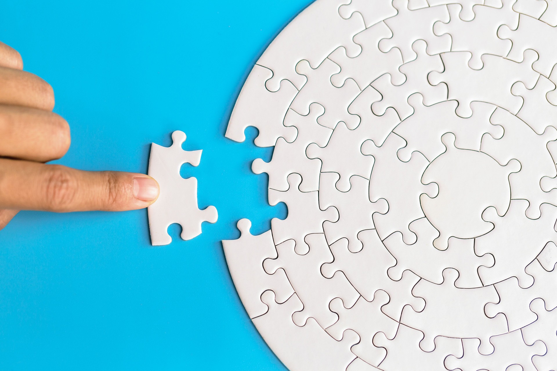 Hand legte das letzte Puzzleteil, um die Mission abzuschließen. Abschluss der letzten Aufgabe, fehlende Puzzleteile und Geschäftskonzept mit einem Puzzleteil fehlt.