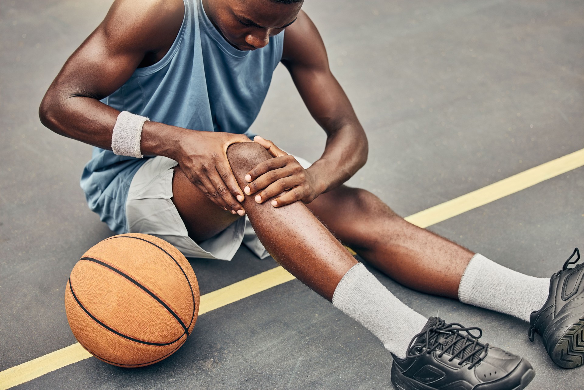 Fitness, Basketball-Knieverletzung oder Schmerzen auf dem Basketballplatz mit dem Bein beim Training, Training oder Sporttraining. Profisportler, Gesundheits- oder Sportler mit Unfall bei Straßenspiel oder Veranstaltung